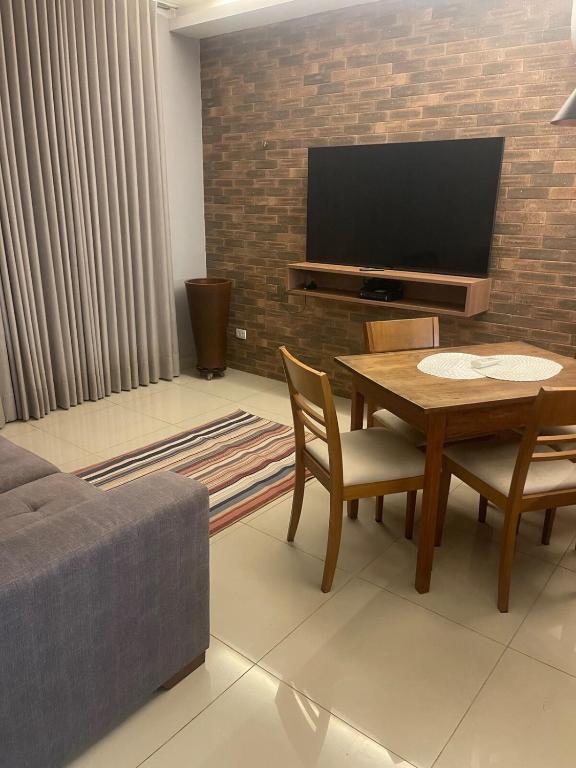 a living room with a table and a tv at Apartamento ao lado do Mercado Central Edifício Fidelis in Goiânia