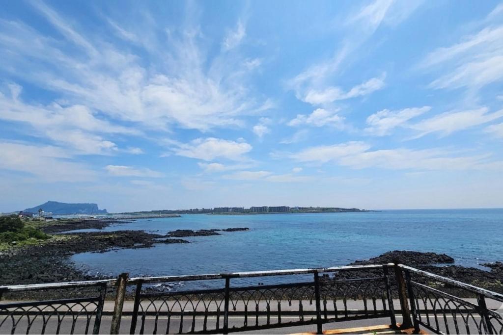 a view of a body of water with a fence at Haemorat Pension in Seogwipo