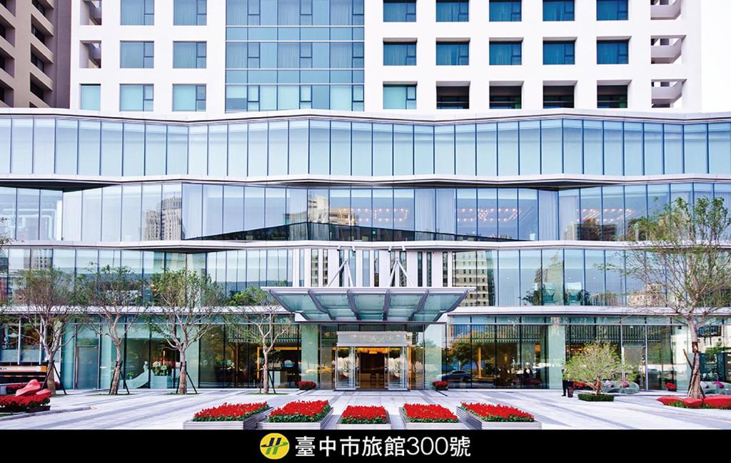 a large glass building with a fountain in front of it at Millennium Hotel Taichung in Taichung