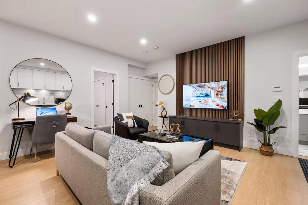 a living room with a couch and a tv at The North Shore Luxe Suite in North Vancouver