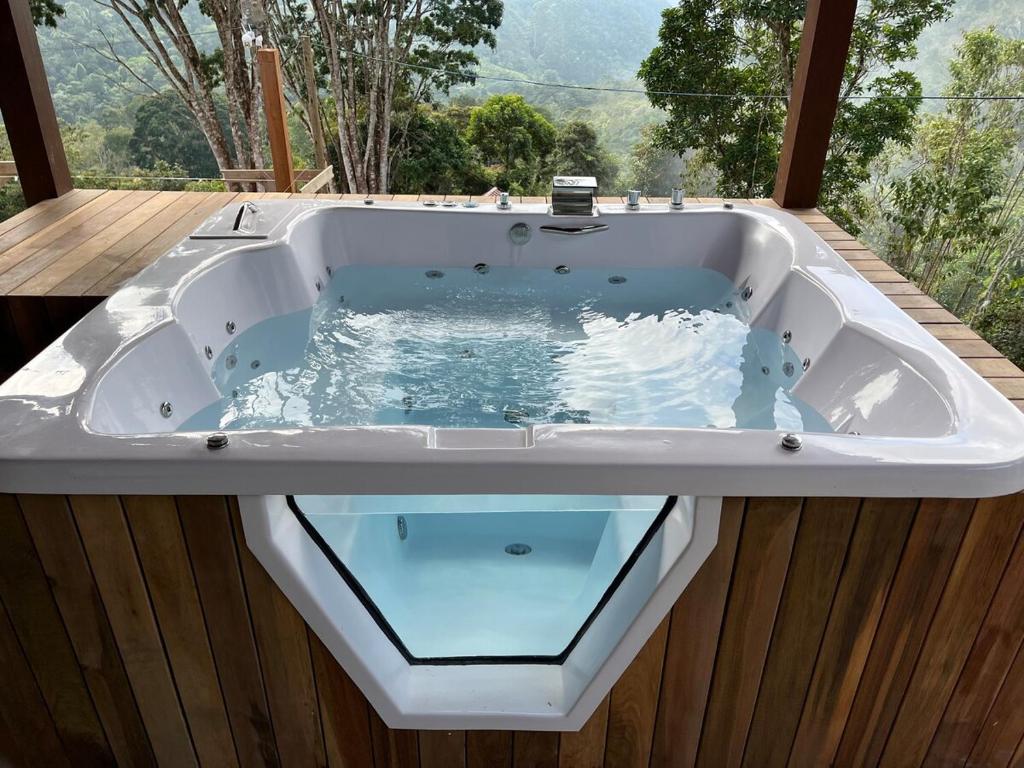 a jacuzzi tub with a window in it at Recanto Bougainville ST in Santa Teresa