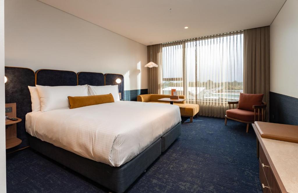 a hotel room with a large bed and a desk at Hotel Panorama in Clapham