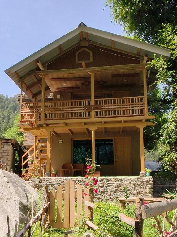a log cabin with a large porch and a deck at Tiny house soyal in Kulu