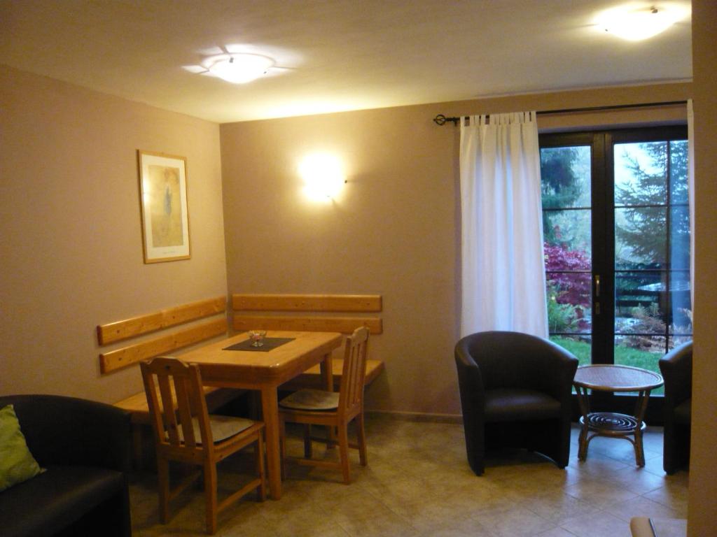 un soggiorno con tavolo, sedie e una finestra di Privát Welcome a Rokytnice nad Jizerou