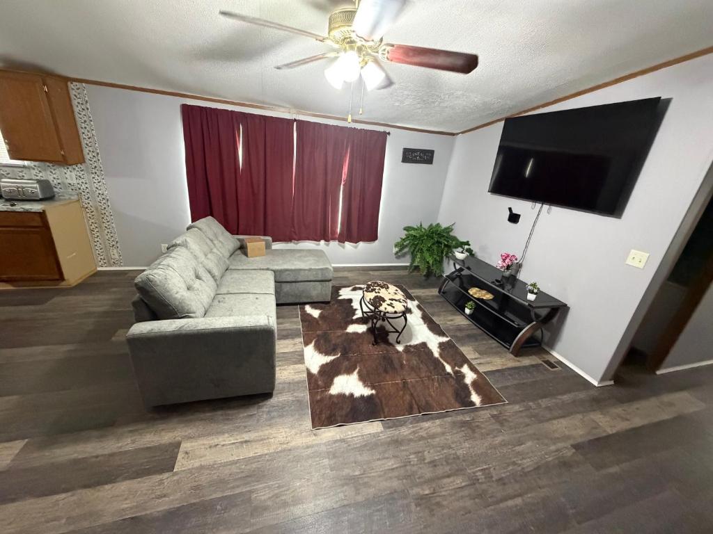 a living room with a couch and a flat screen tv at The Hidden Creek Hideaway in Huntsville