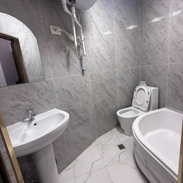 a white bathroom with a sink and a toilet at Geniuses in Samarkand