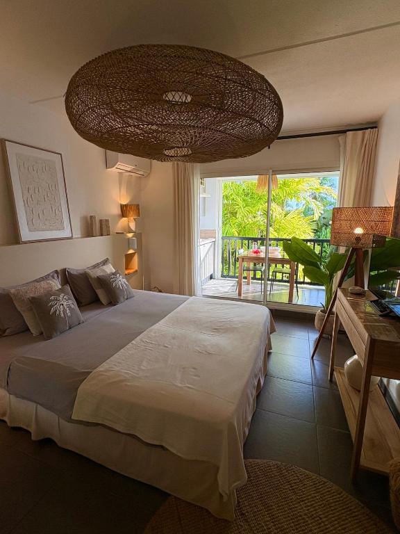 a bedroom with a large bed and a large window at Studio Atoumo Marine 5 in Saint-François