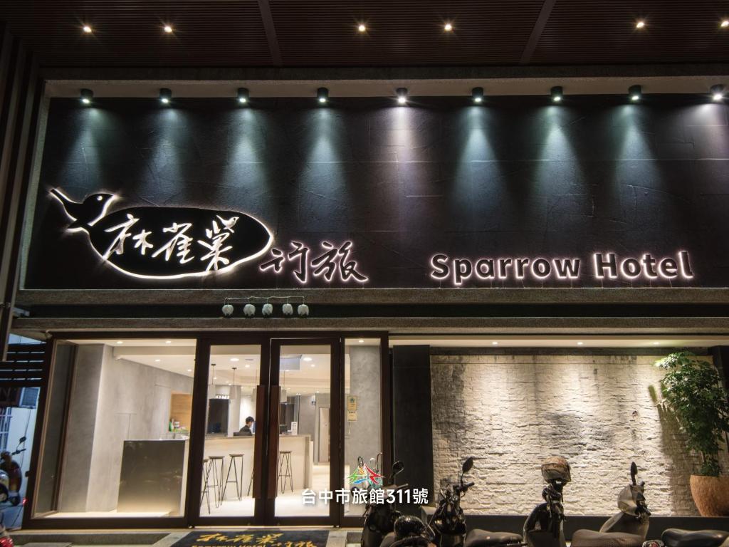 a sign for a sparrow hotel on the side of a building at Sparrow Hotel in Taichung