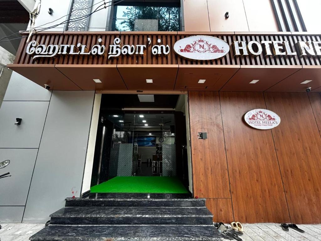 a hotel entrance with stairs and a green floor at S Hotel Neela in Musiri