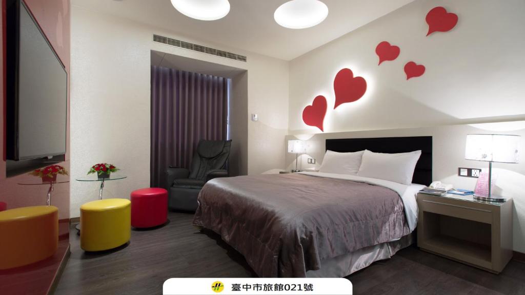a hotel room with a bed and hearts on the wall at Eusta Motel in Taichung