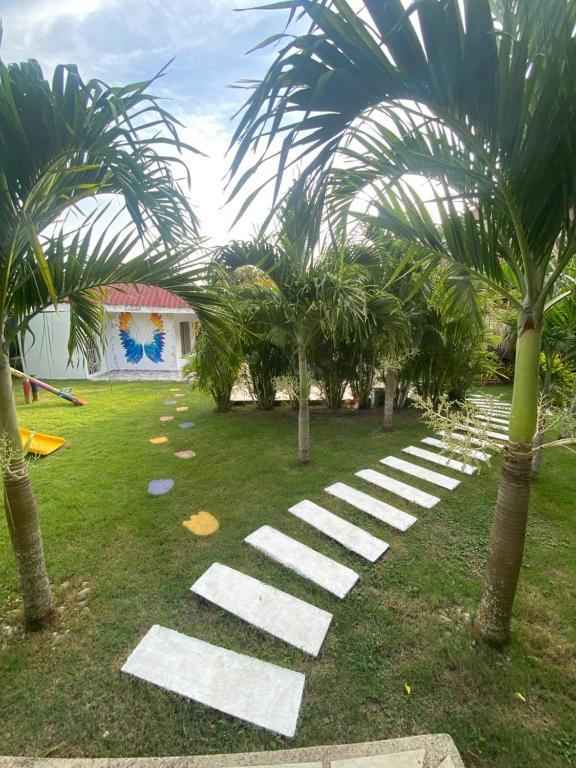 a garden with white stepping stones and palm trees at Dream Country Cabin in Cañaveral