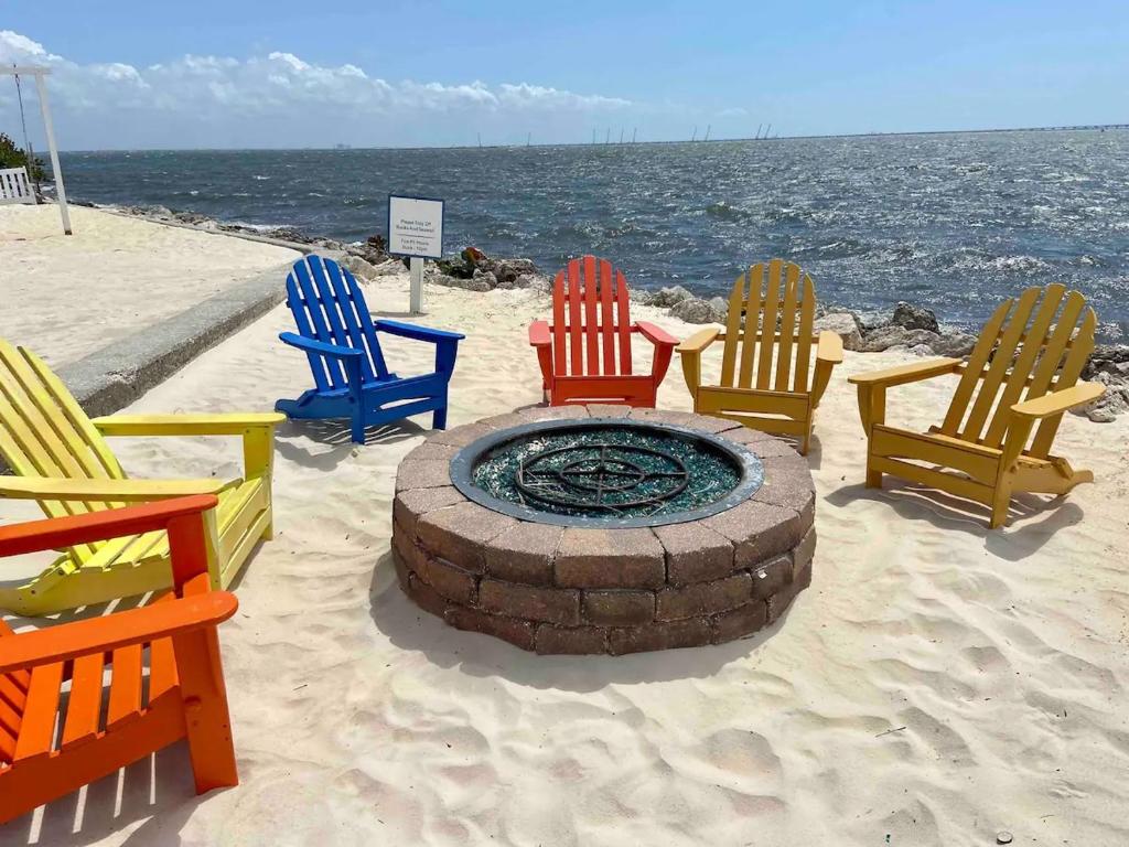 a group of chairs sitting around a fire pit on the beach at Bayfront 2BR2BA Condo at Sailport Minutes from Beaches & Downtown Attractions in Tampa