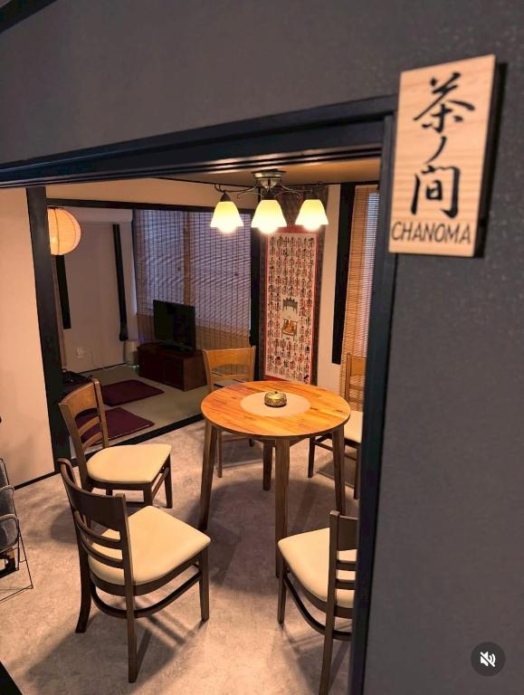 a dining room with a table and chairs and a sign at 旅籠小龍 in Kochi