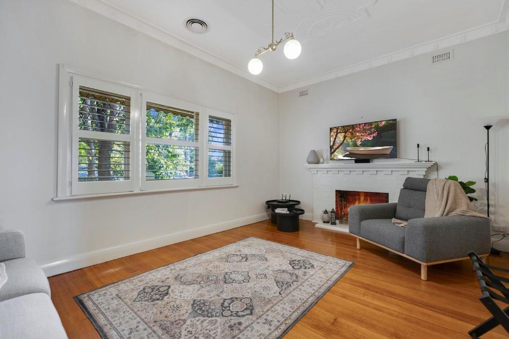 a living room with a chair and a fireplace at Barkly Cottage Bendigo in Bendigo