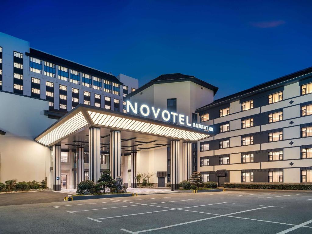 a novation hotel with a parking lot in front of it at Novotel Changshu Yushan in Changshu