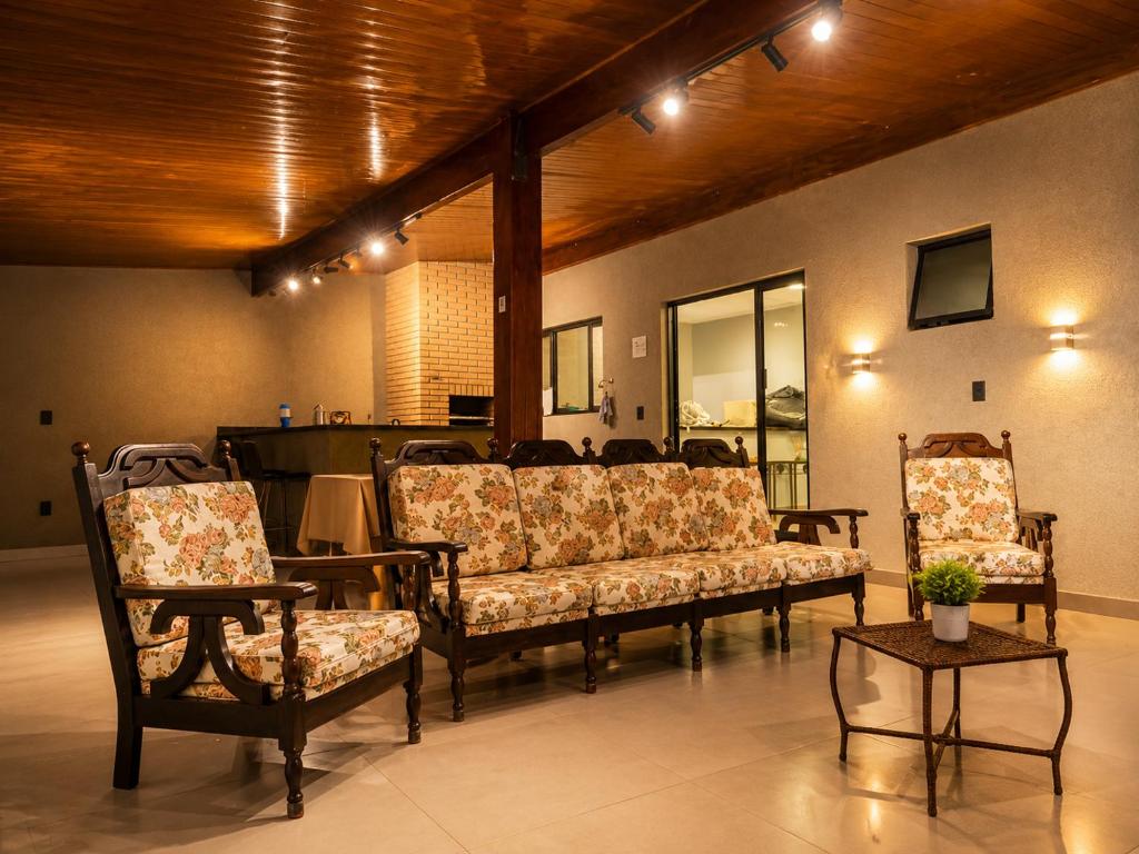 a living room with couches and chairs and a table at Casa Aconchegante com Espaço Gourmet in Itatiba