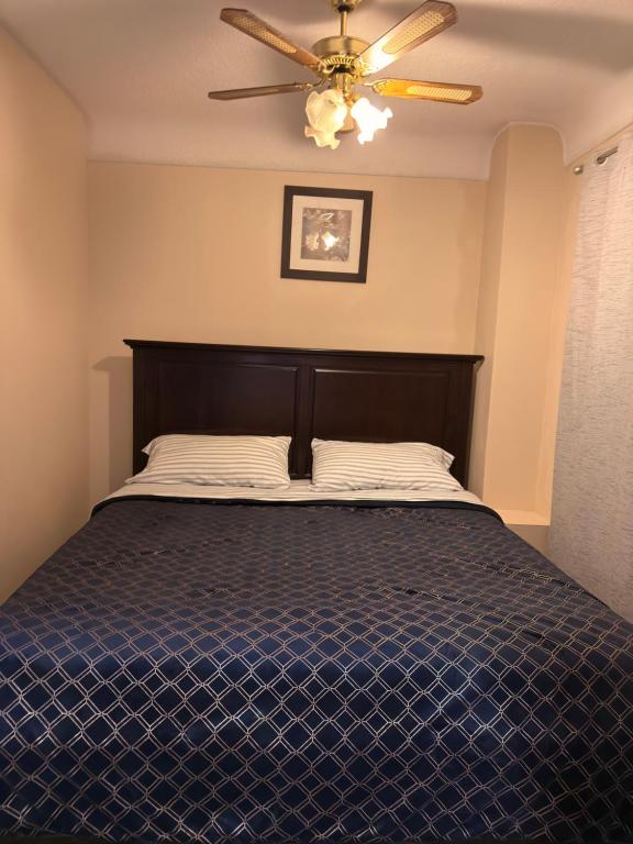 a bedroom with a bed with a ceiling fan at Oshawa Duplex in Oshawa