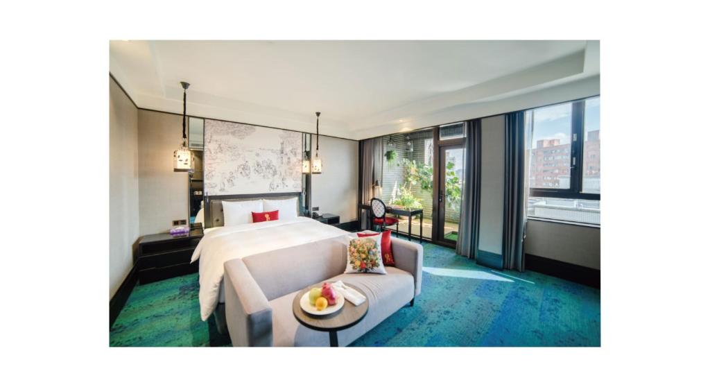 a hotel room with a bed and a couch at Just Palace Hotel in Taipei