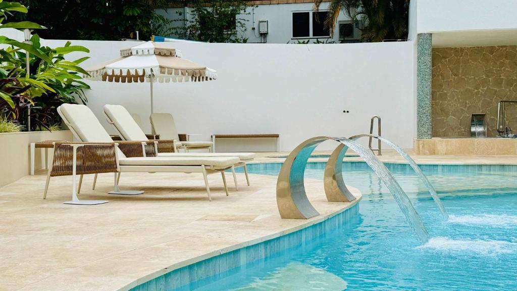a swimming pool with chairs and a water slide at Bella Vista Coral Sea Views in Port Douglas