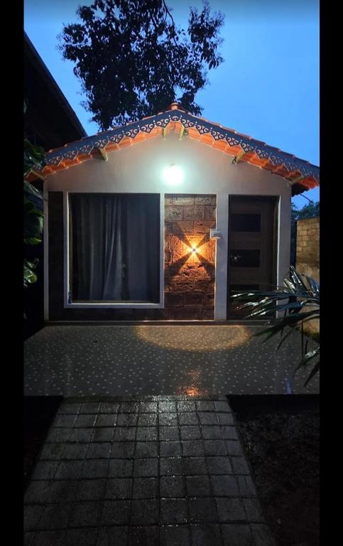 a small house with a light on the side of it at Villa Retreat Cottages Ramnagar in Londa