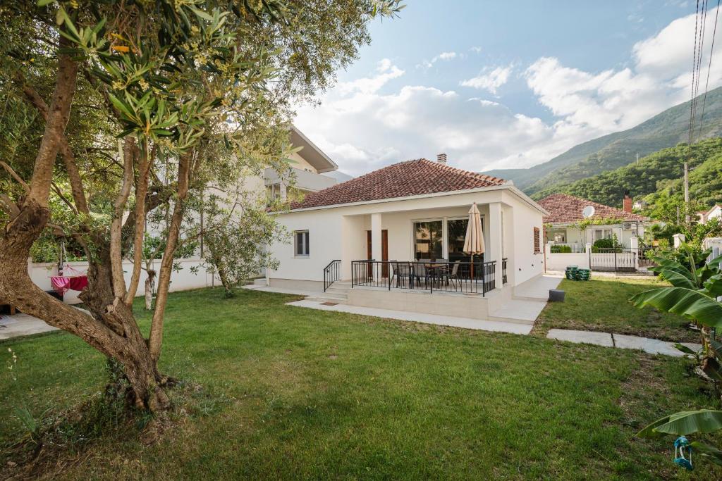 a white house with a green yard at House Olive Tree in Bijela