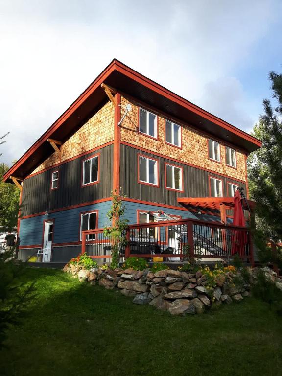 a large wooden house with a gambrel roof at GROWL Lodge - Hot Tub & Mountain Views! in Golden