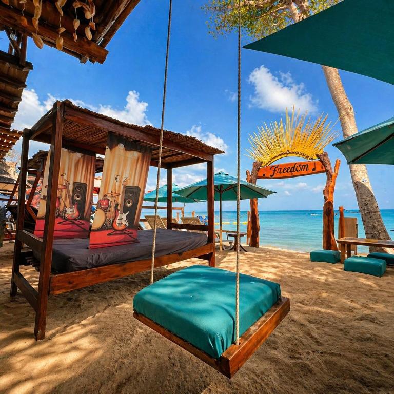 a swing bed on a beach with the ocean at Freedom Beach Club in Barú