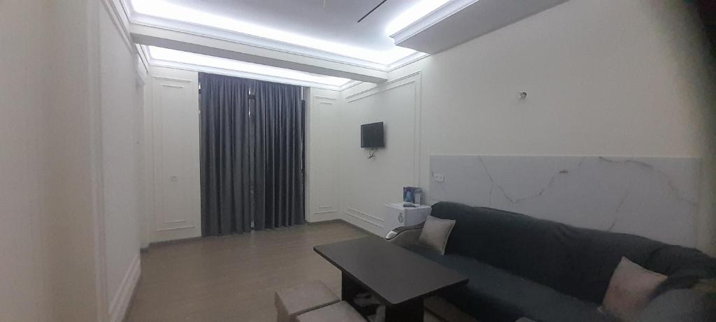 a living room with a couch and a table at Hakim Karim Apartments in Khujand