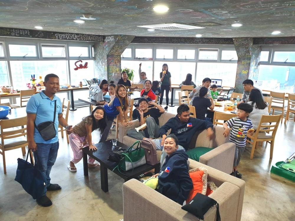 a group of people sitting on couches in a room at popcorn hostel haeundae in Ch'ŏngsap'o