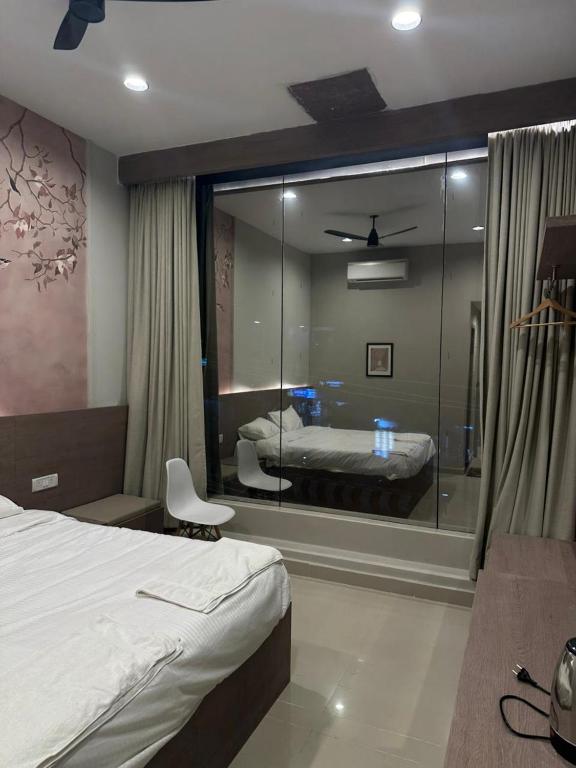 a bedroom with a bed and a large glass window at King Residency in Chennai