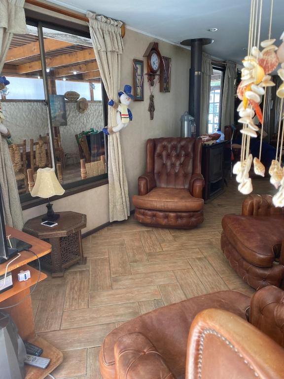 a living room with leather chairs and a couch at Spacious Beach House with Pool for Relaxing in El Quisco