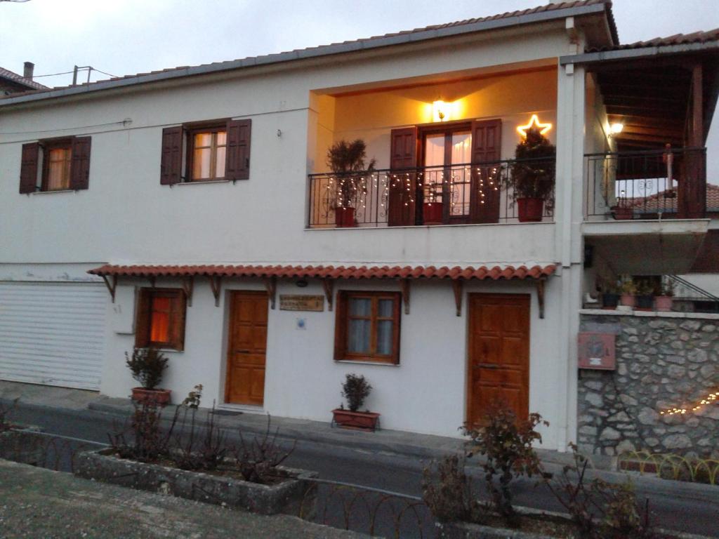 ein weißes Haus mit Balkon auf einer Straße in der Unterkunft Zephyros in Vitina