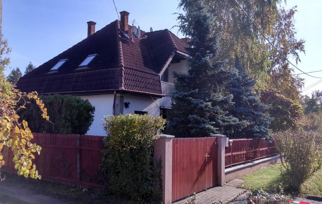 een huis met een rood hek ervoor bij Fecske Home Zamárdi in Zamárdi