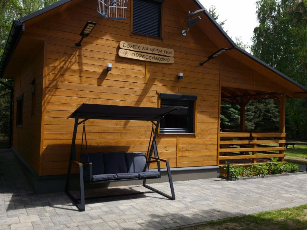 a porch swing in front of a cabin at Odpoczynkowo in Orle