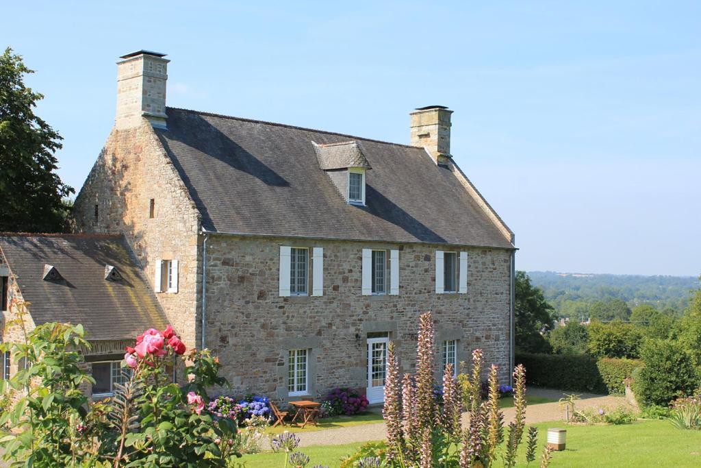 a large brick house with a roof at Les Goubelins in La Lande-dʼAirou