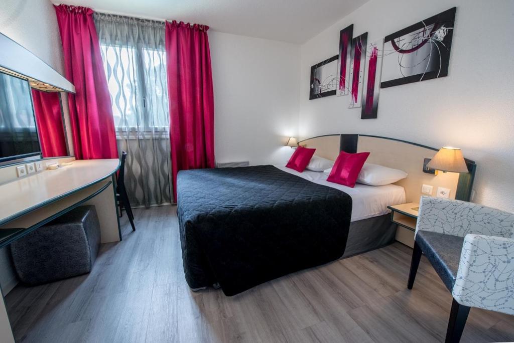 a hotel room with a bed and red curtains at Citotel Hôtel Le Capricorne in Marmande