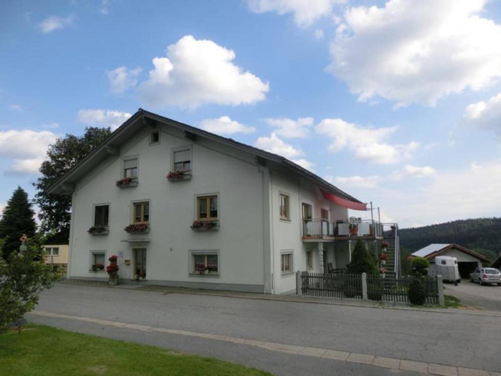 a white building with a black roof at Ferienhaus Gustl in Bischofsreut