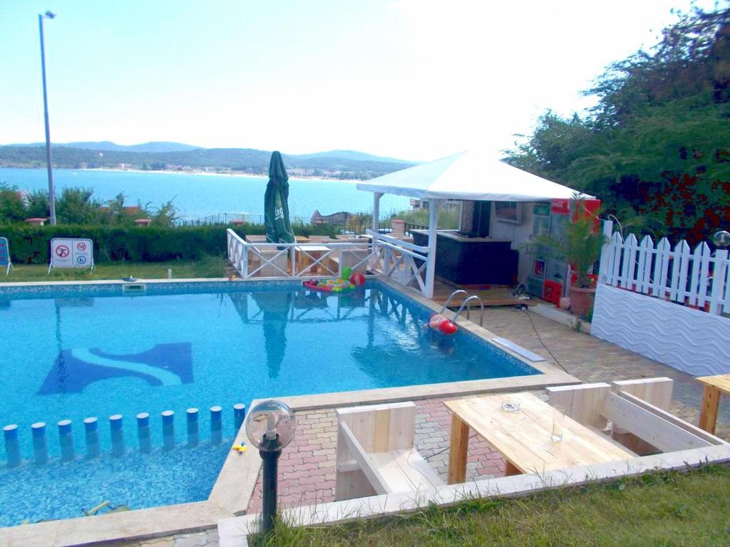 Una gran piscina con vista al agua. en Safo Apartments and Rooms, en Sozopol