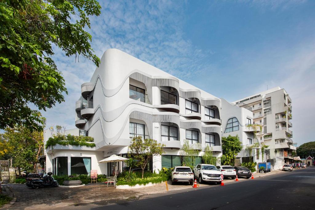ein weißes Gebäude, vor dem Autos parken in der Unterkunft Thadatra INN in Phnom Penh