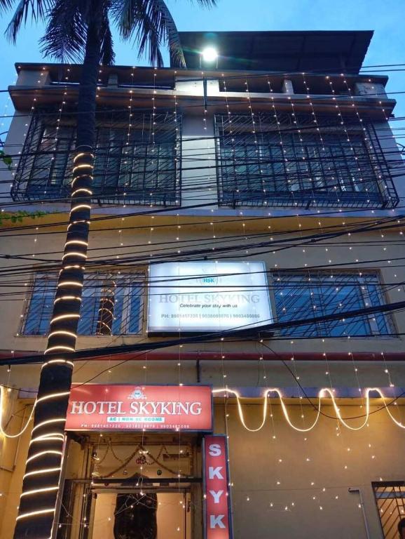a building with a palm tree in front of a store at HOTEL SKYKING in Gauripur