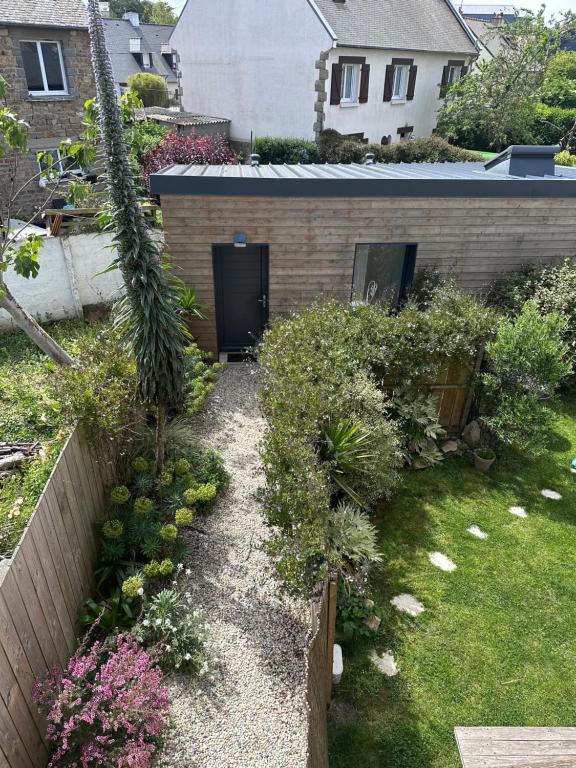 a backyard with a garden with plants and a building at Le Cabanon Malouin in Saint Malo