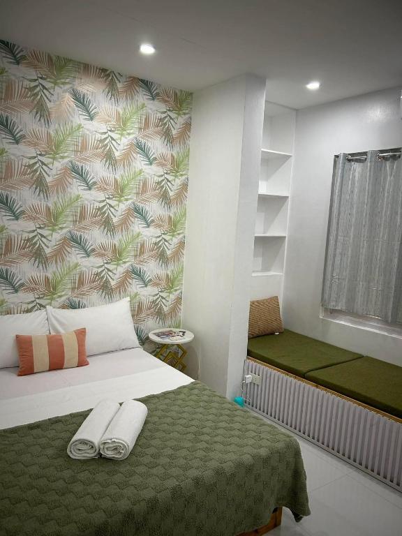 a bedroom with a bed with two towels on it at Kyle's Bed and Breakfast DMall Boracay in Boracay