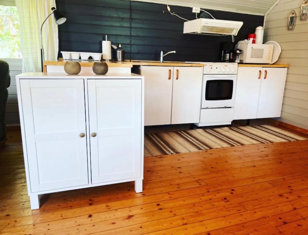 a kitchen with white cabinets and a microwave at Bakerstu in Skage i Namdalen