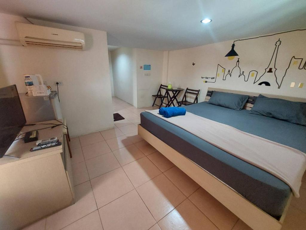 a bedroom with a large bed and a television at TaKaYai GuestHouse in Cha Am