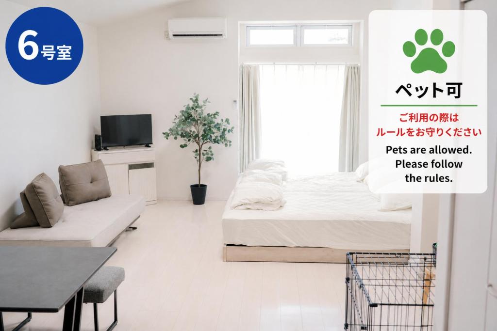 ein Schlafzimmer mit einem Bett, einer Couch und einem Fernseher in der Unterkunft Green Field in Sasebo