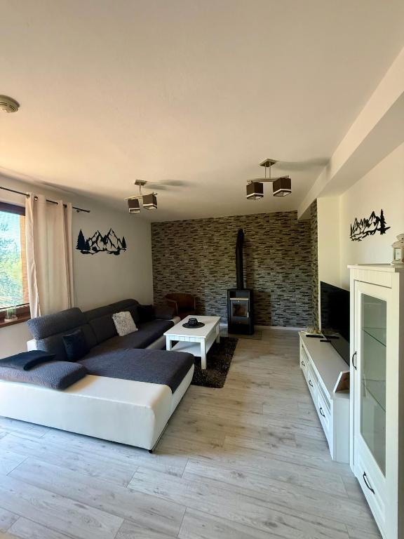 a bedroom with a large bed and a living room at Apartmán Lara -Lesná in Stará Lesná