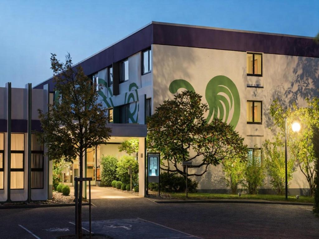 a building with a green sign on the side of it at Sunday Hotel Saarbrücken Süd in Saarbrücken