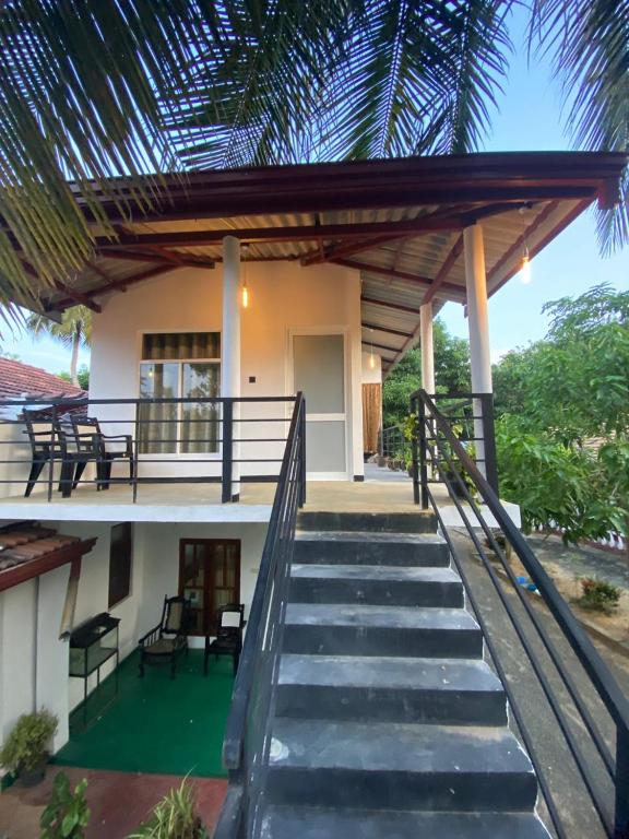 a house with a staircase leading up to it at New Vilard in Tissamaharama