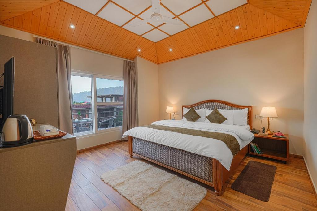 a bedroom with a bed and a large window at Reejas inn's n' suites in Kasauli