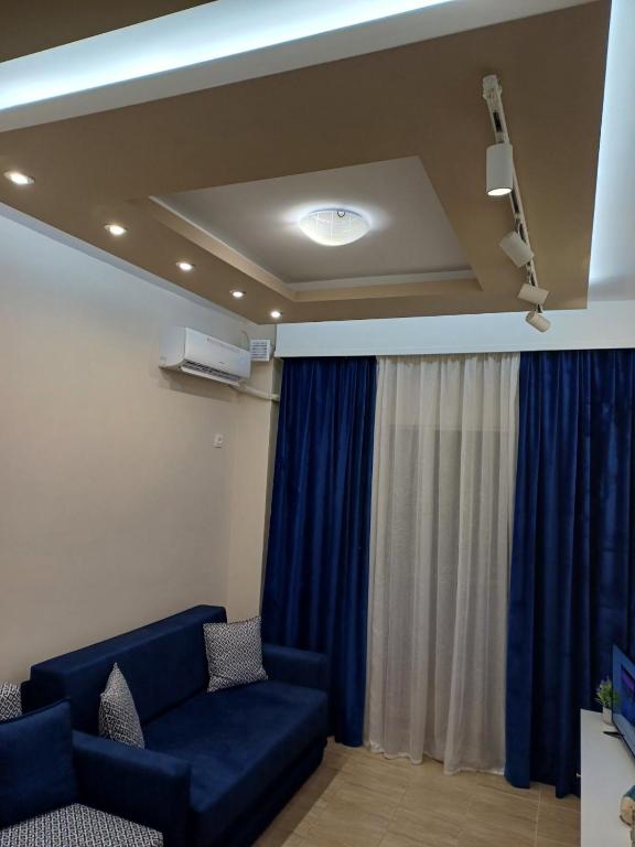 a living room with a blue couch and a window at Apartment Natasha in Paralia Katerinis